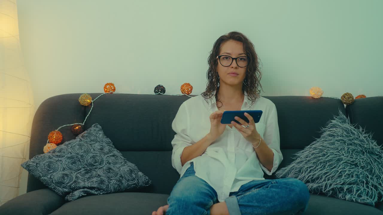 mujer usando un teléfono inteligente en un sofá