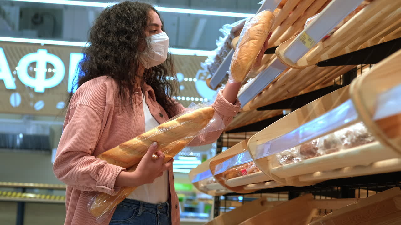 식료품 가게 에서 바게트 를 구입 하는 여자