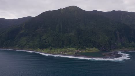 coastal-rural-village,-a-church,-a-lagoon,-with-lush-green-cliffs-landscape,-Fajã-de-Santo-Cristo,-São-Jorge-island,-the-Azores,-Portugal