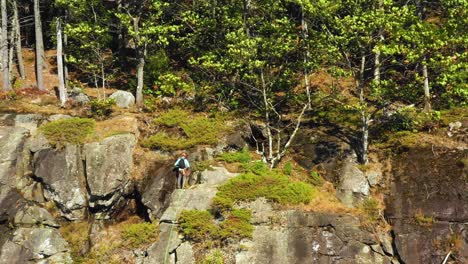 imágenes aéreas orbitan alrededor de un escalador solitario en la cima de un acantilado en maine