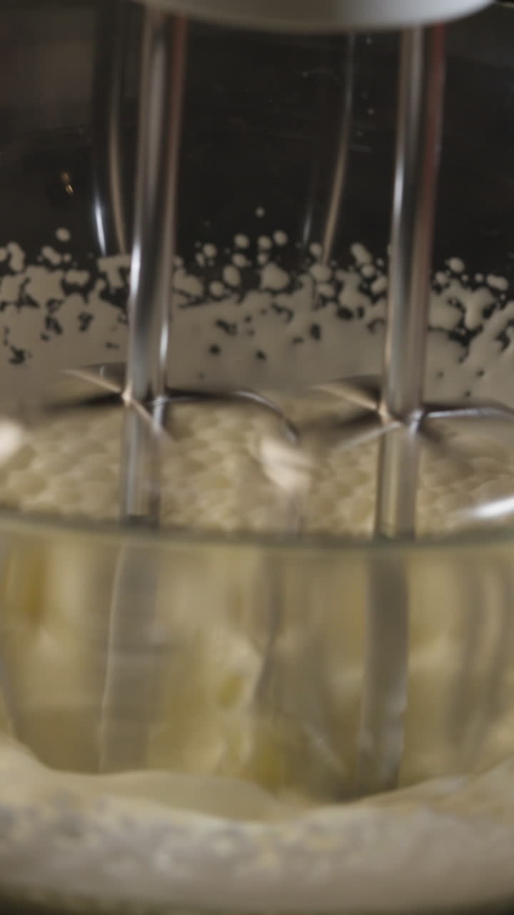 Sbattitore mescola l'impasto in una ciotola di vetro - Primo piano, Scatto verticale