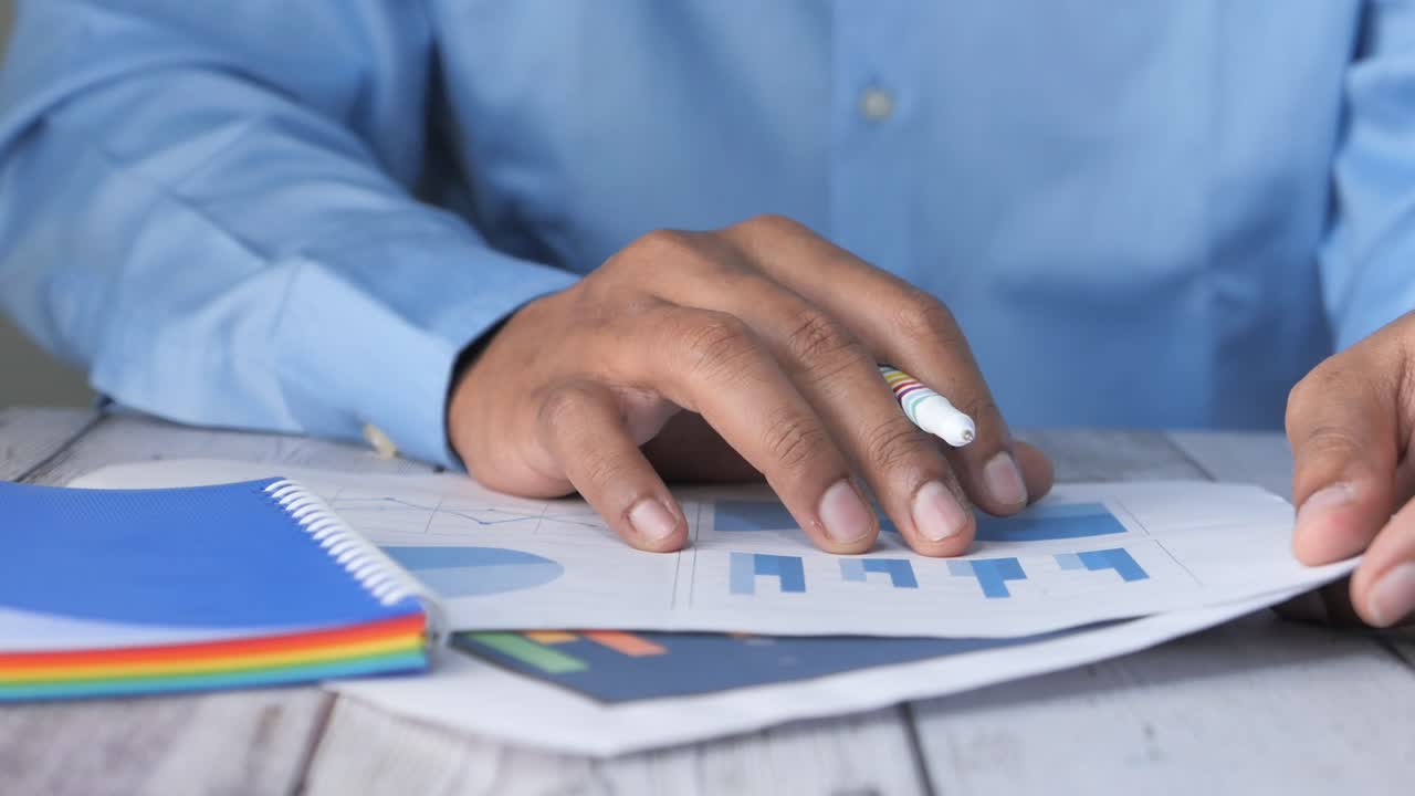 hombre de negocios revisando gráficos y gráficos financieros en su escritorio