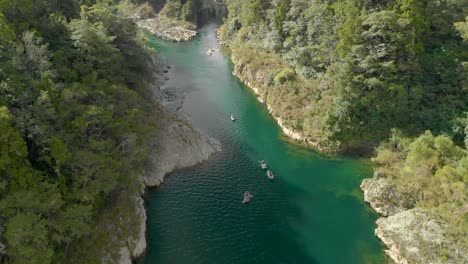 slowmo - people on canoe tour paddle beautiful pristine clear blue pelorus river, new zealand - aerial drone