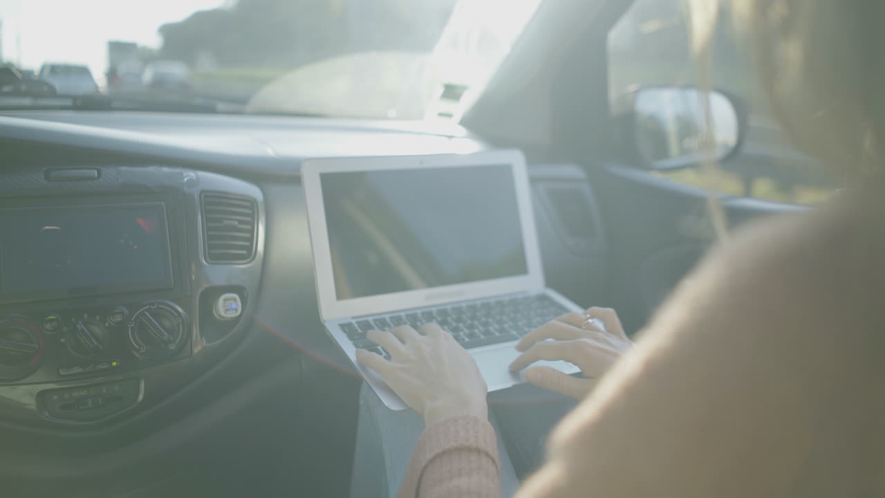 mujer usando computadora portátil en el coche