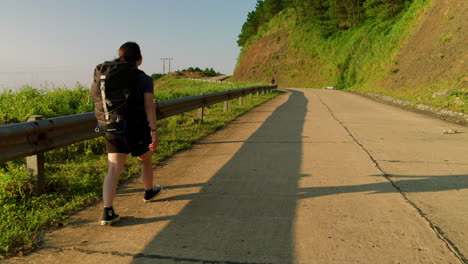 Eine-Junge-Wanderin-Mit-Rucksack-Geht-Auf-Ihrer-Wanderung-Selbstbewusst-Eine-Steile-Straße-Hinauf