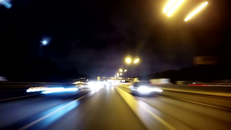 night road pov through the city at night timelapse. view of the cars behind. loopable