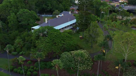 aerial view drone fly around colonial-georgian style newstead house heritage museum at the bank of breakfast creek surrounded by green trees and grassy lawn, brisbane inner city suburb