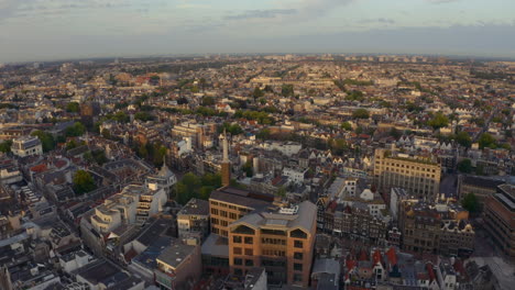 Slider-Drohne-Schoss-Zur-Goldenen-Stunde-Des-Sonnenaufgangs-über-Damrak-Im-Zentrum-Von-Amsterdam