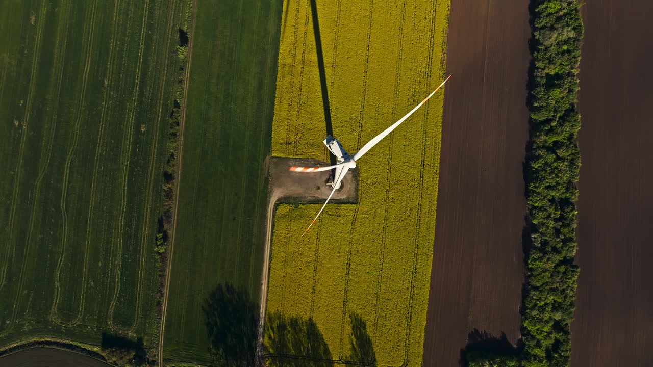 Top down drone shot of wind turbine in a wind farm during the day, renewable energy
