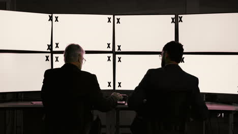 businessmen in a control room reviewing data