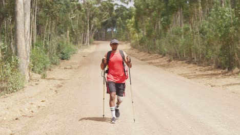 sporty mixed race man with prosthetic leg hiking