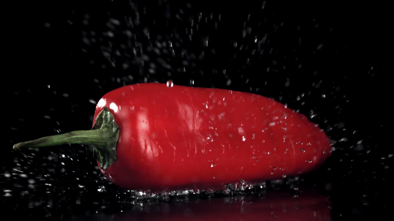 Fresh Red Pepper Dropping into Water in Slow Motion