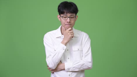 sad young asian businessman thinking while looking down