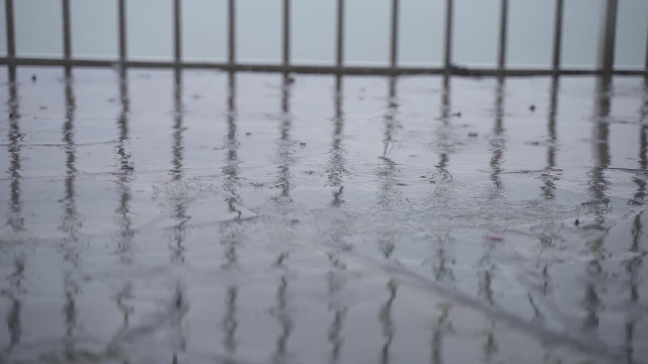 돌 타일 위에 떨어지는 비방울의 느린 움직임  ⁇