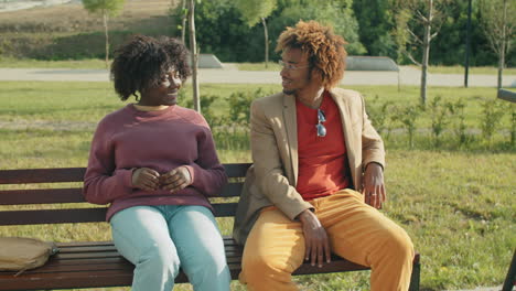 Hombre-Y-Mujer-Afroamericanos-Hablando-En-Un-Banco-En-El-Parque
