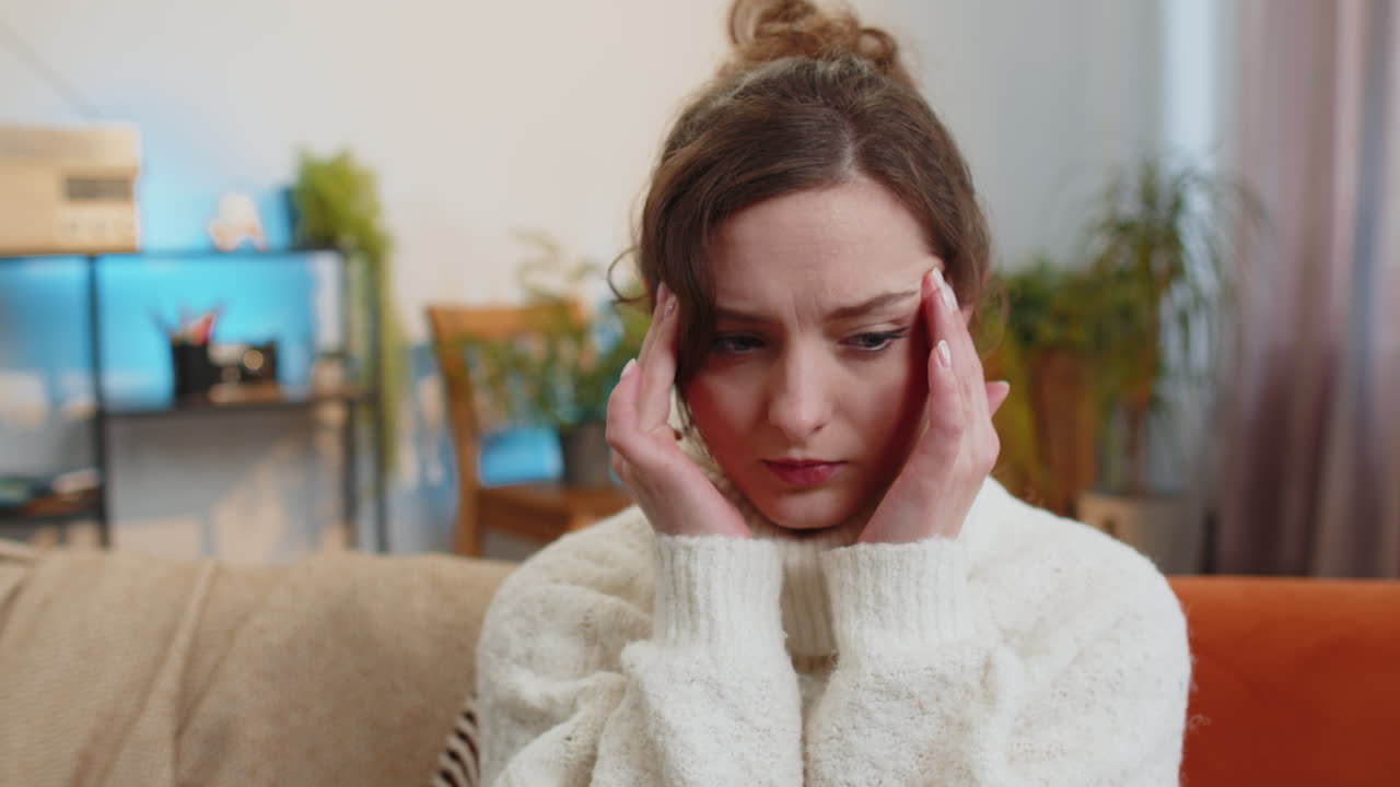 Displeased young woman rubbing temples to cure headache problem suffering from migraine stress