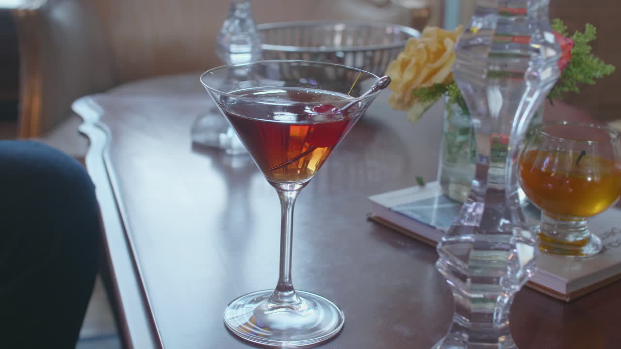 Clip showing a person carefully pouring a martini into a glass on an elegantly set table.