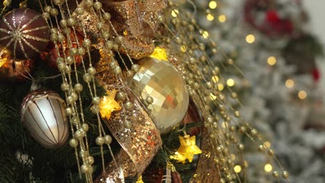 close-up of christmas tree with gold and red ornaments. the tree is illuminated with lights. 4k.