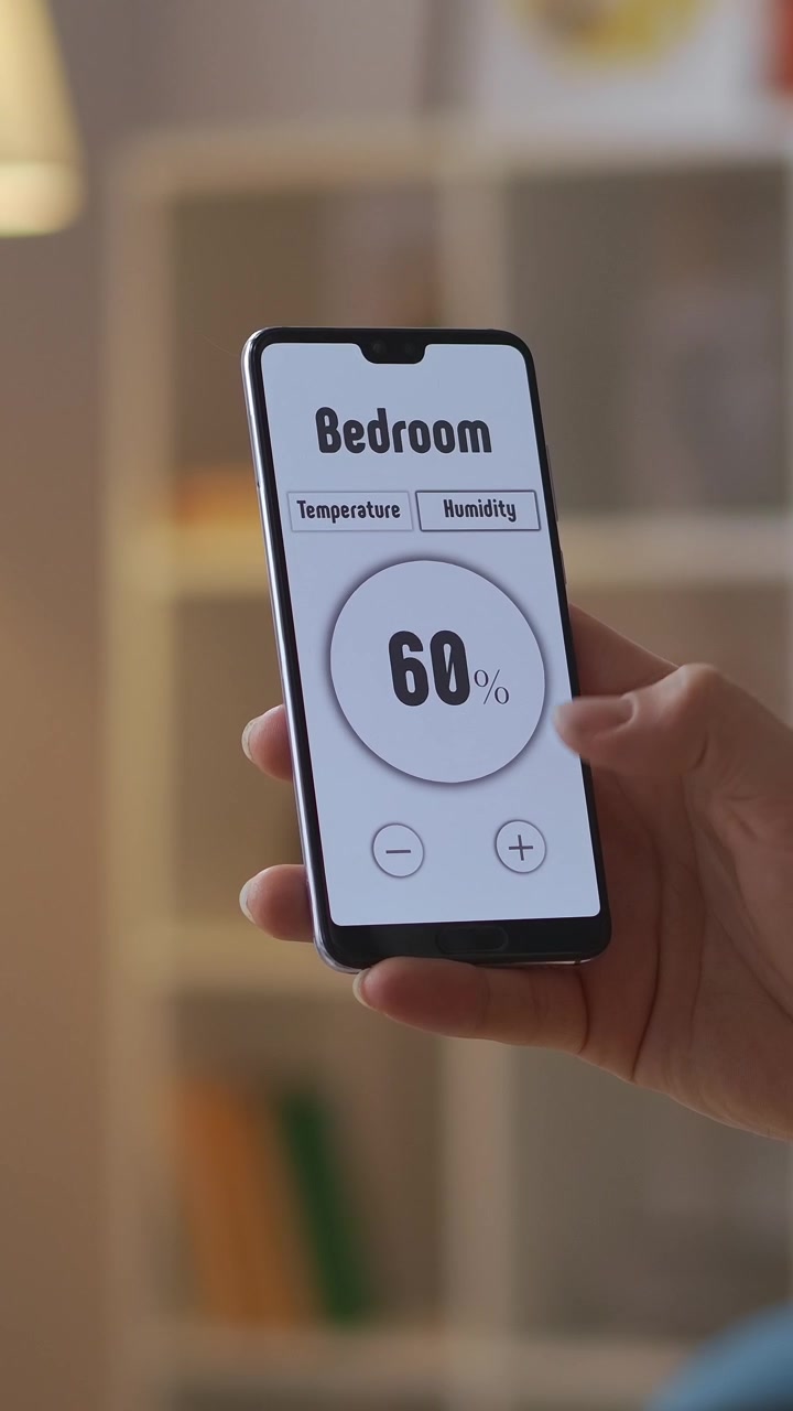 Close-Up of Hand Controlling Smart Home System with Smartphone App