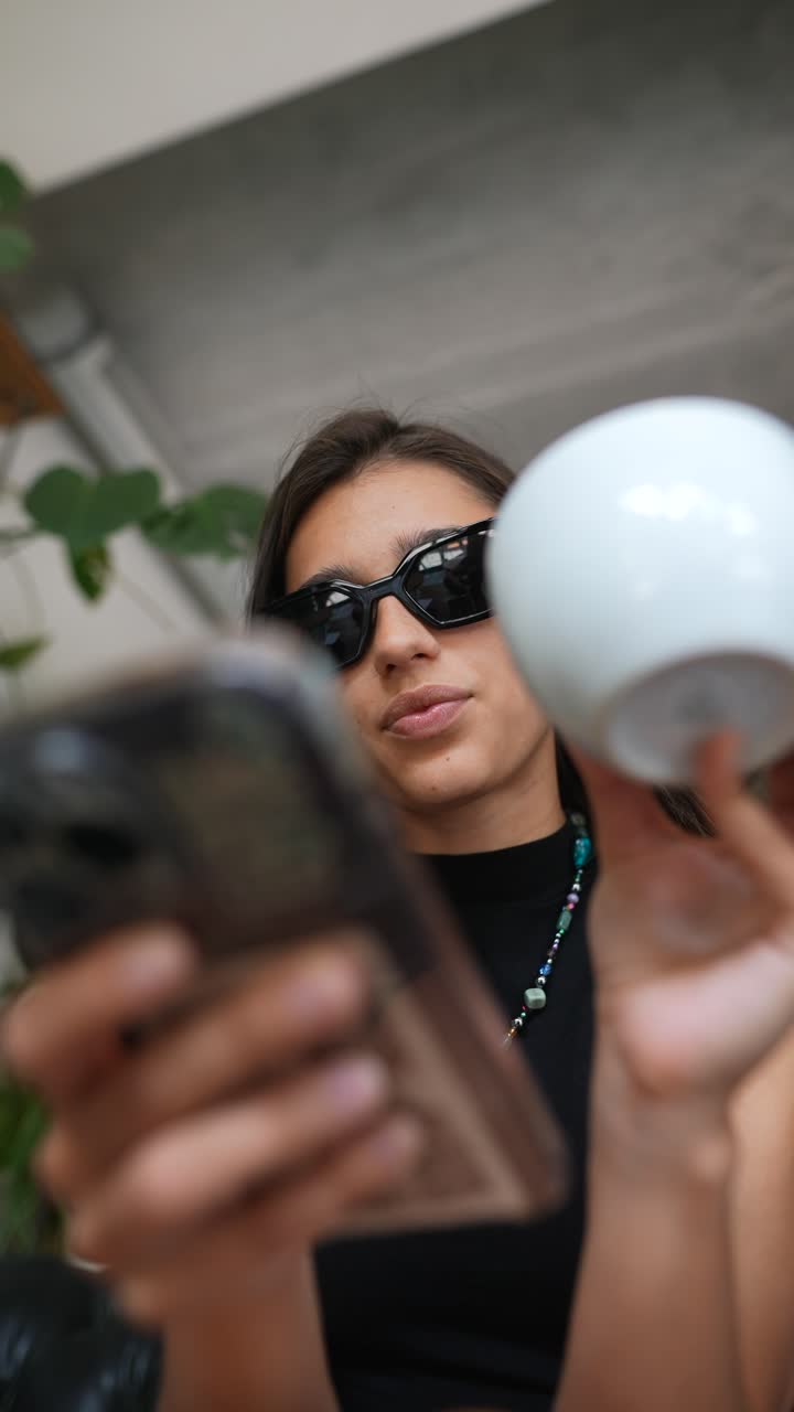 mujer mirando un teléfono y un cuenco blanco