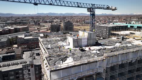 vista aérea de los trabajadores de la construcción en el techo de un nuevo edificio