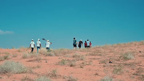 people planting trees in sharjah's desert as part of the uae's 'plant the emirates' initiative