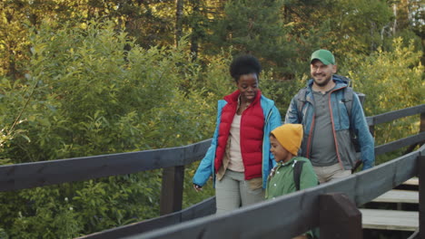 multiethnic tourist family walking in national park