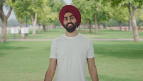 Happy-Sikh-Indian-man-lifting-heavy-dumbbells-in-park