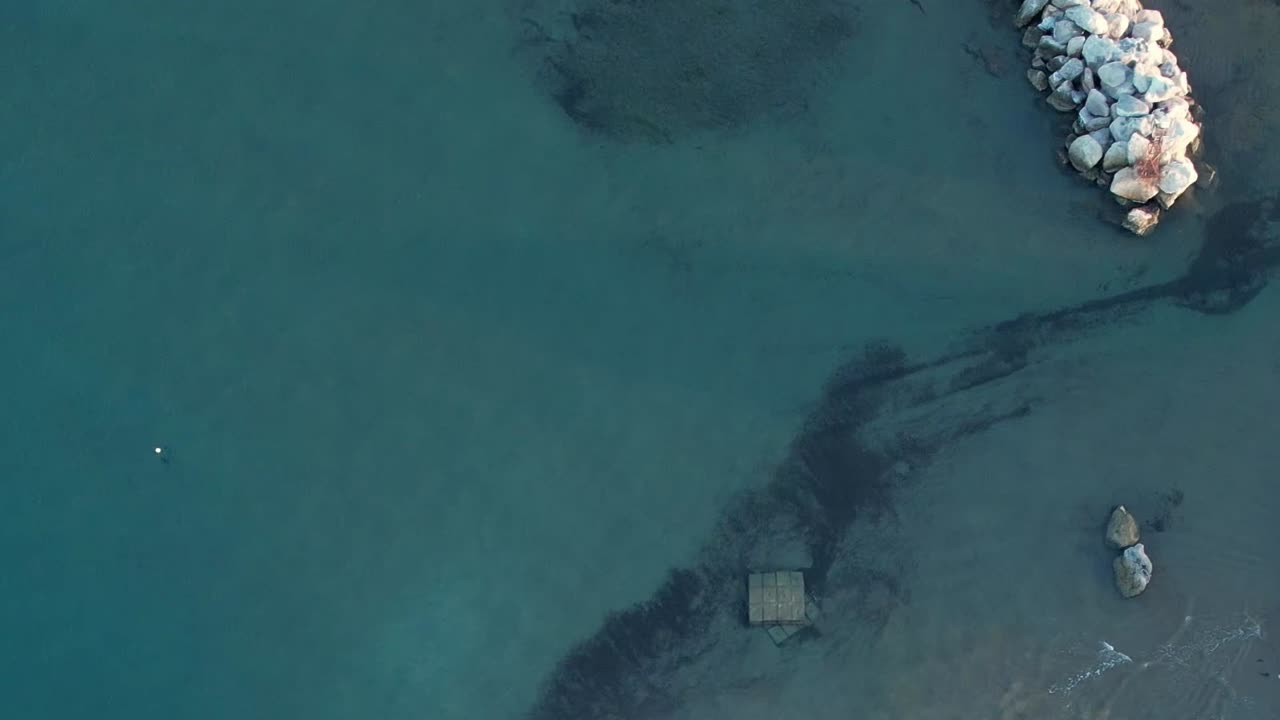 Crystal clear waters near rocky shores in Greece from above