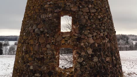 aerial close up of abandoned historic windmill ruins with sun rays breaching through.