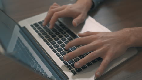 Manos-Masculinas-Escribiendo-En-Una-Laptop-Trabajando-Desde-Casa