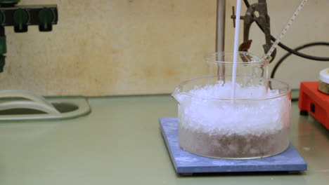 chemical solution for experiment on glass beaker cooled with ice in laboratory of the university of coimbra, portugal