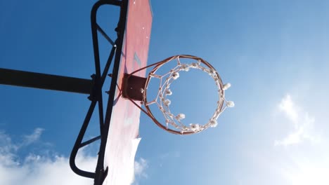 basket ball hoop from bellow on sunny day against blue sky