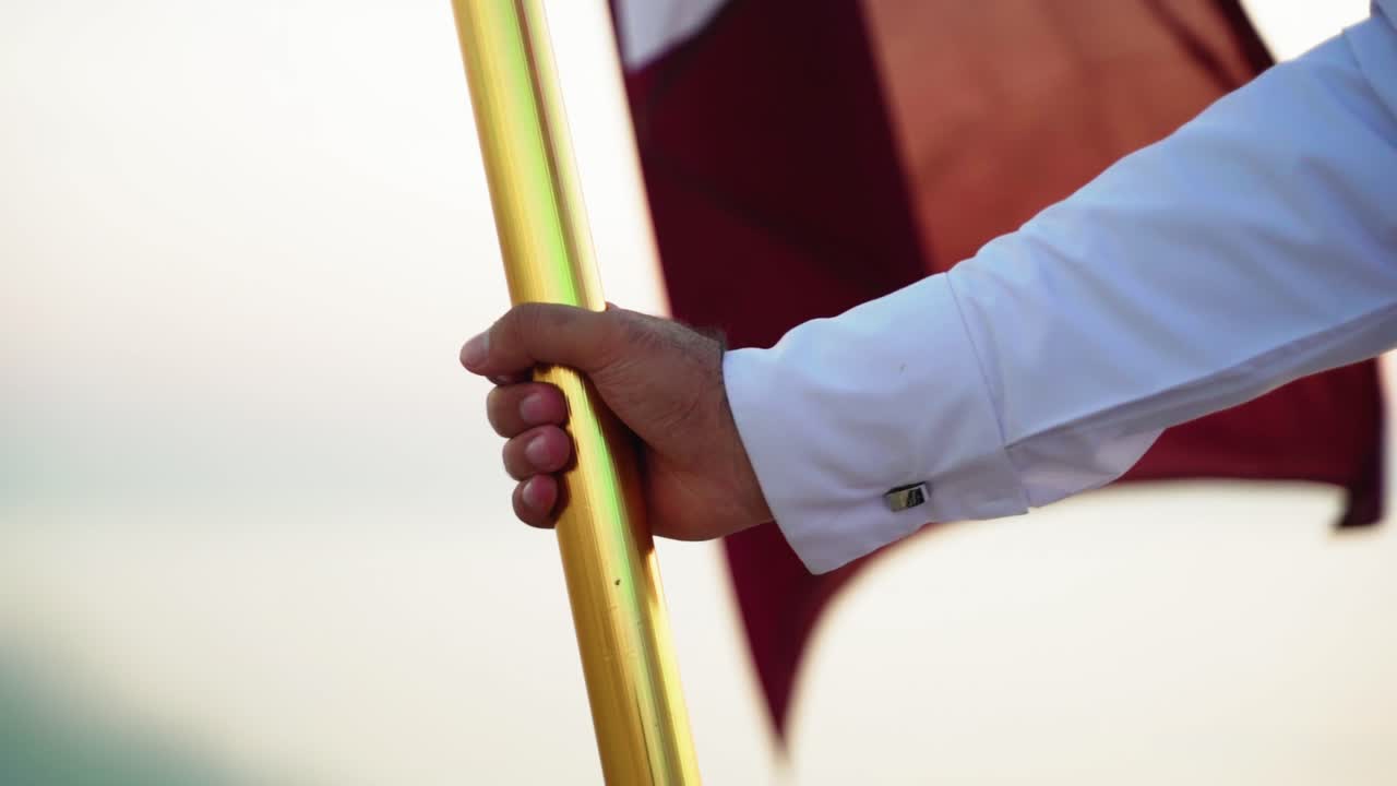 Un cavaliere con la bandiera del Qatar a cavallo vicino al mare nel deserto del Qatar-1