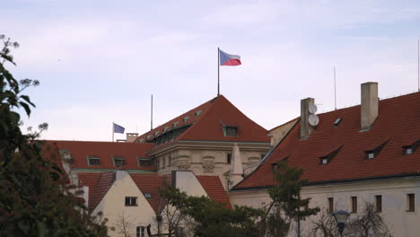 czech republic and european union flag moving in the wind on the rooftops of old buildings in the historical part of prague