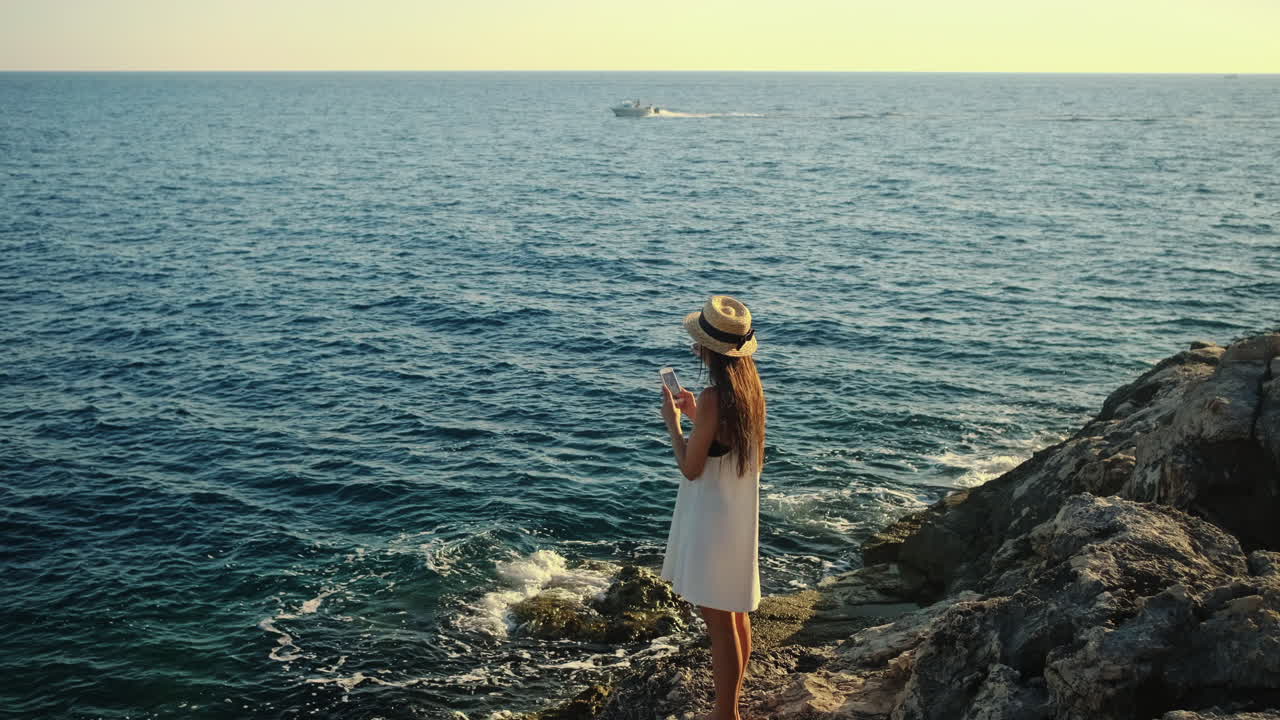 바다를 내려다보는 절벽에 있는 여자