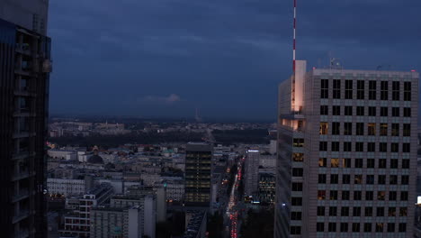 Los-Delanteros-Vuelan-Alrededor-De-Las-Cimas-De-Los-Rascacielos-Después-Del-Atardecer.-Ciudad-De-Noche-Con-Coches-En-Calle-Muy-Transitada.-Varsovia,-Polonia