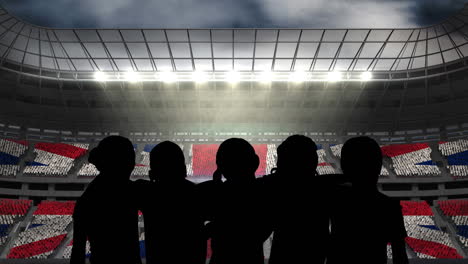 animation of silhouettes of team of sports women with british flag over sports stadium