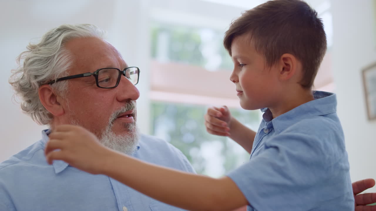 abuelo sonriente mirando a su nieto. niño alegre sentado en los regazos de los abuelos