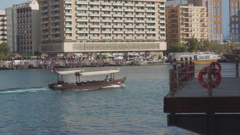 Crucero-Tradicional-Abra-En-Dubai-Creek-Cerca-Del-Distrito-De-Al-Fahidi-En-Dubai,-Emiratos-árabes-Unidos---Tiro-De-Seguimiento