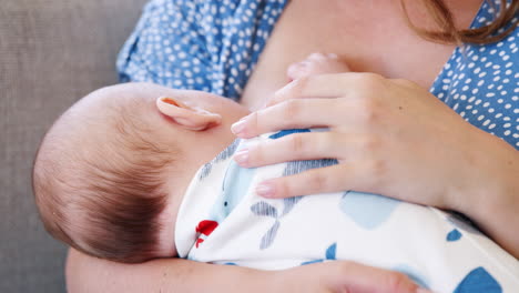 Nahaufnahme-Einer-Mutter-In-Zeitlupe,-Die-Zu-Hause-Auf-Dem-Sofa-Sitzt-Und-Ihr-Baby-Stillt