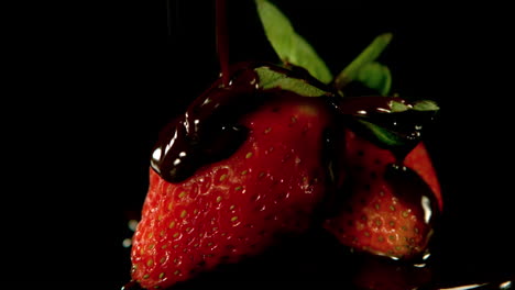 melted chocolate pouring over strawberry