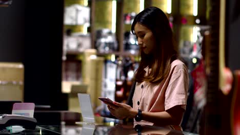 young woman paying by scanning qr code with smartphone