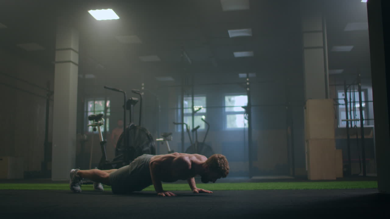 체육관에서 푸시업을 하는 남자. 푸시업과 운동 후 호흡과 호흡. 피트니스와 운동에 완벽합니다. 젊은 스포츠맨은 체육관에서 푸시업을 합니다. 운동선수는 피트니스에 종사합니다.