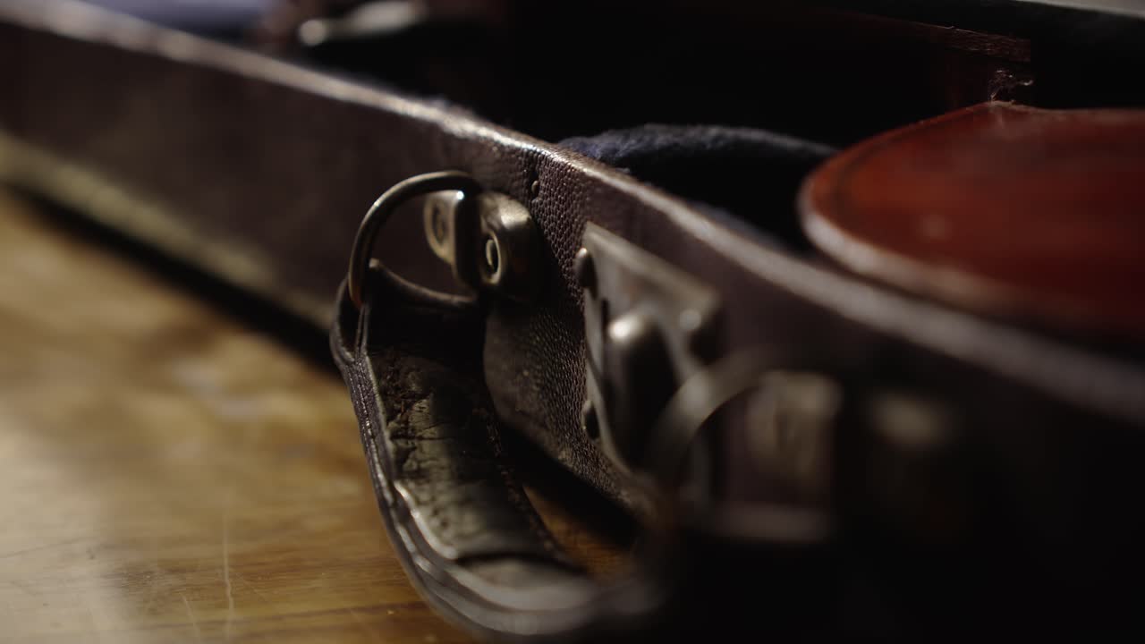 Musician opens vintage case and removes antique violin CLOSE-UP