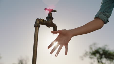 Bäuerin-Wäscht-Sich-Die-Hände-Unter-Leitungswasser-Auf-Einem-Ländlichen-Bauernhof-Mit-Süßwasser,-Das-Aus-Dem-Wasserhahn-Fließt,-Während-Die-Nachmittagssonne-Aufflackert