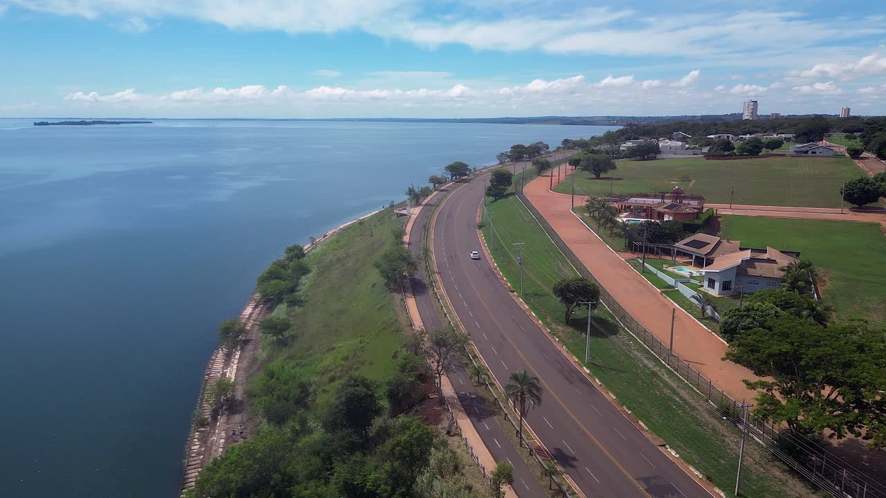 Flyover shoreline road car on Parana River in Pres. Epitacio, Brazil