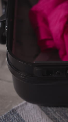 hands of woman opening black suitcase with clothes after arriving to hotel room. female tourist prepares for taking things apart on vacation closeup