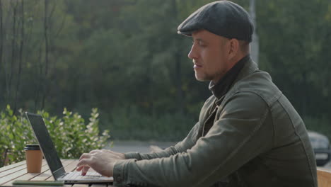 man working on laptop outdoors