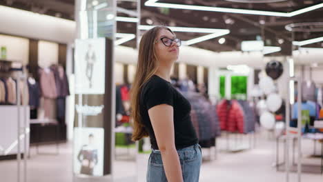 side view of lady in glasses walking in shopping mall with bokeh light in background, featuring clothing store and modern interior design, trendy fashion, and stylish shopping experience